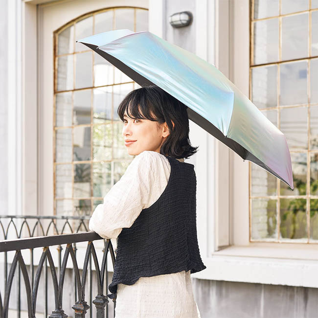 オーロラ遮光折りたたみ傘 オーロラ(SNS-0301027) 窓辺で傘をさす女性の後ろ姿